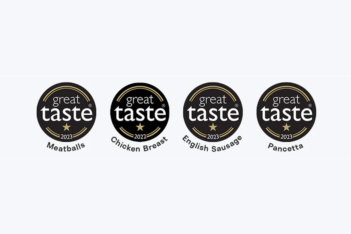 Four Great Taste award badges displaying recognition for Meatballs (2023), Chicken Breast (2022), English Sausage (2023), and Pancetta (2023).
