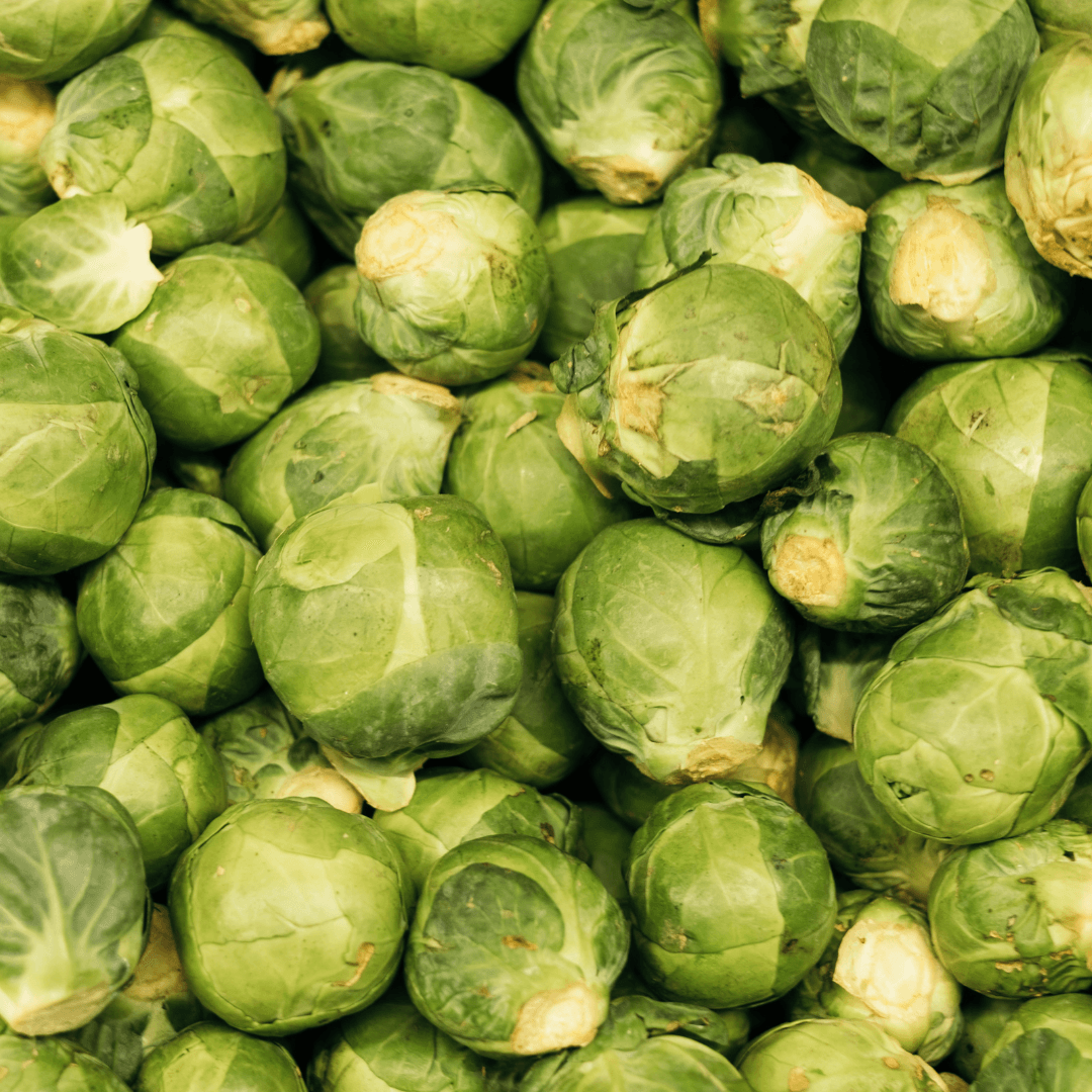 Close-up overhead view of fresh green Brussels sprouts with pale yellow centres, displaying seasonal autumn produce